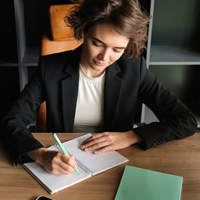 A businesswoman writing down in a notebook