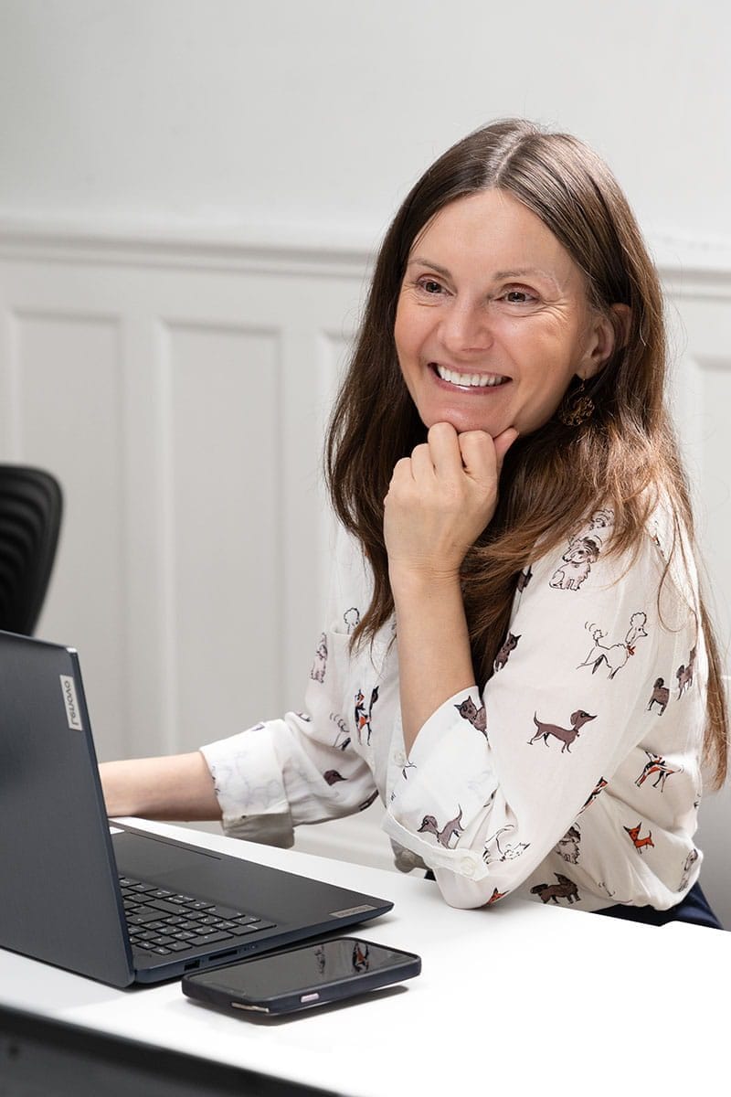 Rosita MacGowan smiling from her desk